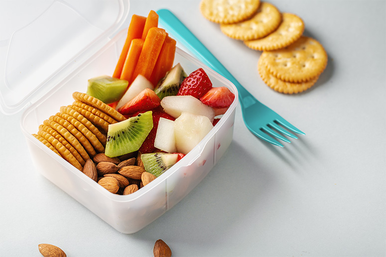 frutas, verduras, almendras, galletas en el plato de un niño