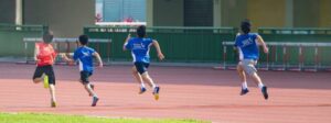 Niños corriendo en pista de entrenamiento atlético.