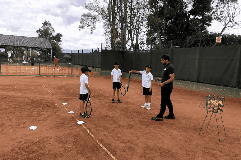 Niños de Athlon con su maestro de tenis